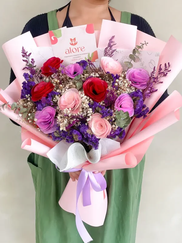 mujer sosteniendo un ramo de flores eternas en color rosado, rojo y morado