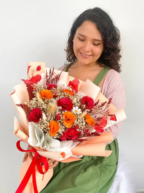 ramo_de_flores_preservadas_rojo mujer con un ramos de flores eternas color rojo