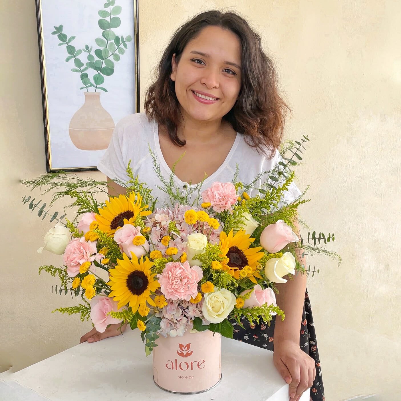 Chica con un arreglo de flores variadas en caja