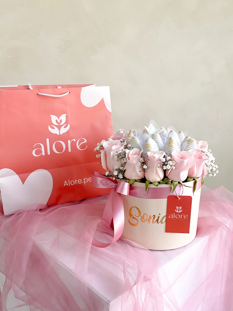 Caja personalizada de rosas rosadas y fresas bañadas en chocolate junto a bolsa de regalo Alore