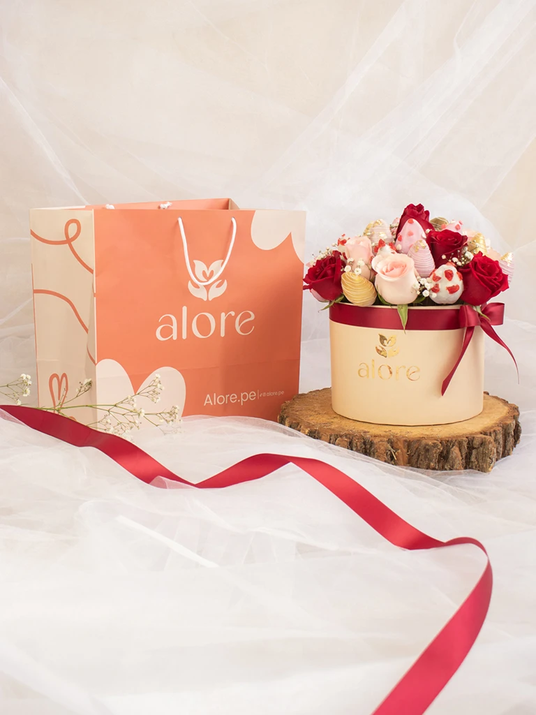 Caja de rosas rojas y rosadas con fresas bañadas en chocolate junto a bolsa de regalo Alore