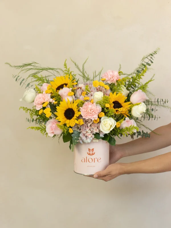 caja_de_flores_amarillas_sostenida caja beige con flores variadas en tonos rosados y amarillos