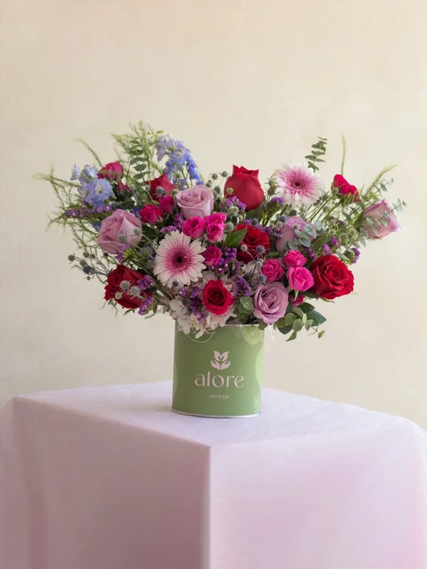 caja_de_flores_fucsias_rojas_y_azules arreglo floral en caja verde con flores rojas y moradas