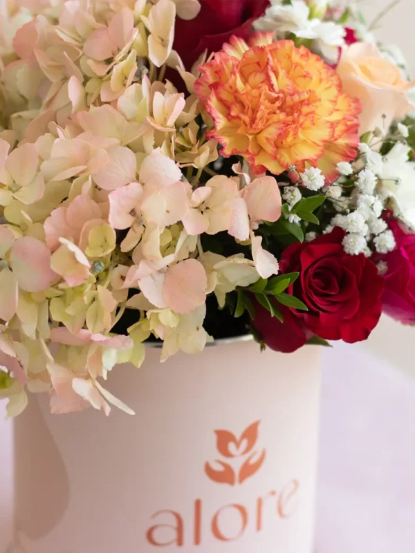 hortensia rosada , rosas rojas y claveles naranjas