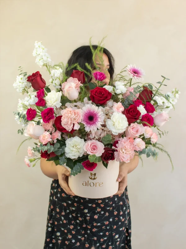 caja_de_flores_rosadas_y_rojas_con_modelo mujer sosteniendo caja gigante de flores premium en color rojo y rosado