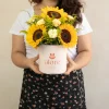 mujer sosteniendo una caja con 5 girasoles de vivero