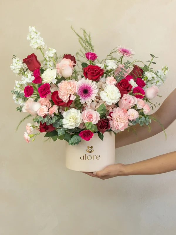 caja_de_rosas_rojas_y_rosadas_premium manos sosteniendo una caja gigante de rosas rojas y flores variadas