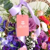 flores lilas y rosadas en canasta etiqueta de alore floreria en una canasta de flores