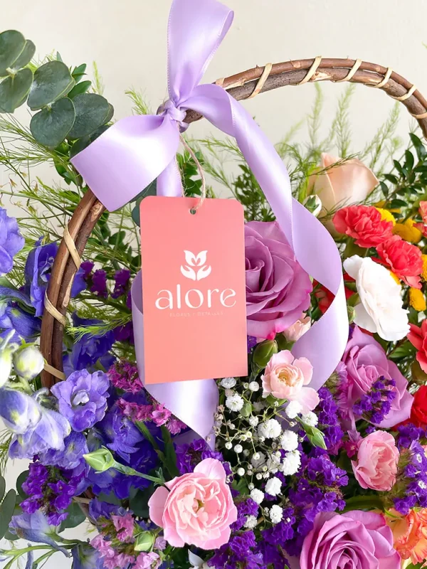 flores lilas y rosadas en canasta etiqueta de alore floreria en una canasta de flores