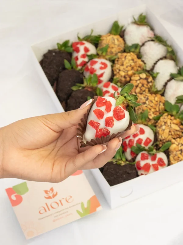 mano_sosteniendo_una_fresa_con_chocolate una fresa decorada con chocolate y cereza