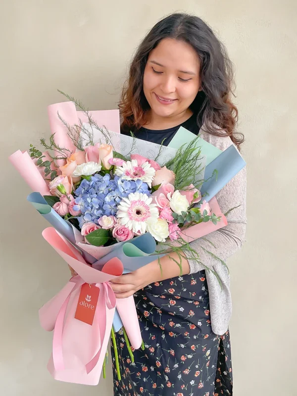 chica con un ramo de flores variadas y envoltura coreana