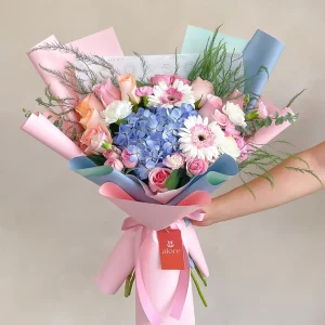 Ramo coreano de hortensia azul, gerberas, rosas y claveles en papel rosado