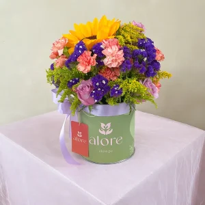 Flores silvestres con girasol, claveles y statice morado en caja verde Alore