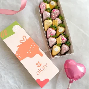 Fresas bañadas en chocolate rosado y dorado con globo corazón