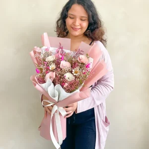 Ramo de flores eternas rosadas con flores secas en papel rosado