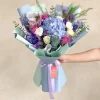 ramo de rosas lilas con flores azules