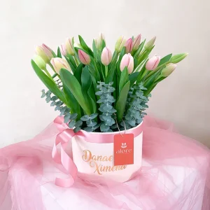 Tulipanes rosados y blancos con eucalipto en caja redonda personalizada