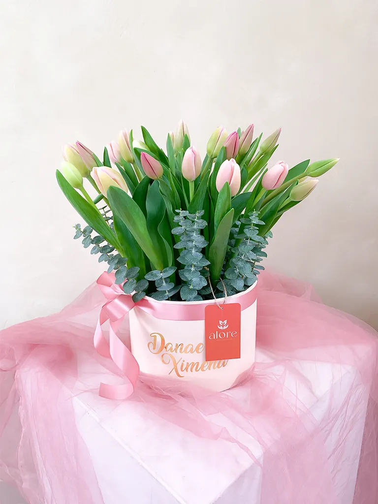 Tulipanes rosados y blancos con eucalipto en caja redonda personalizada