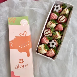 Fresas bañadas en chocolate con la "U" y pelotas de fútbol