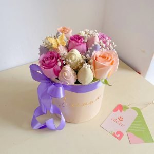 Fresas bañadas en chocolate con rosas lilas y durazno en caja redonda