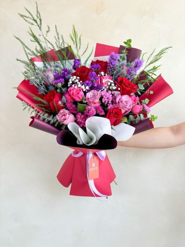 ramo grande con rosas lilas y moradas en envultura roja
