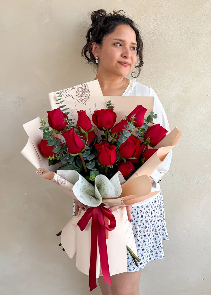 modelo con un ramo de 15 rosas rojas
