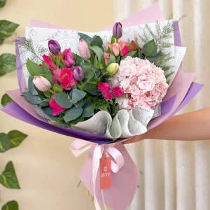 Ramo de tulipanes, hortensia rosada y rosas en papel lila