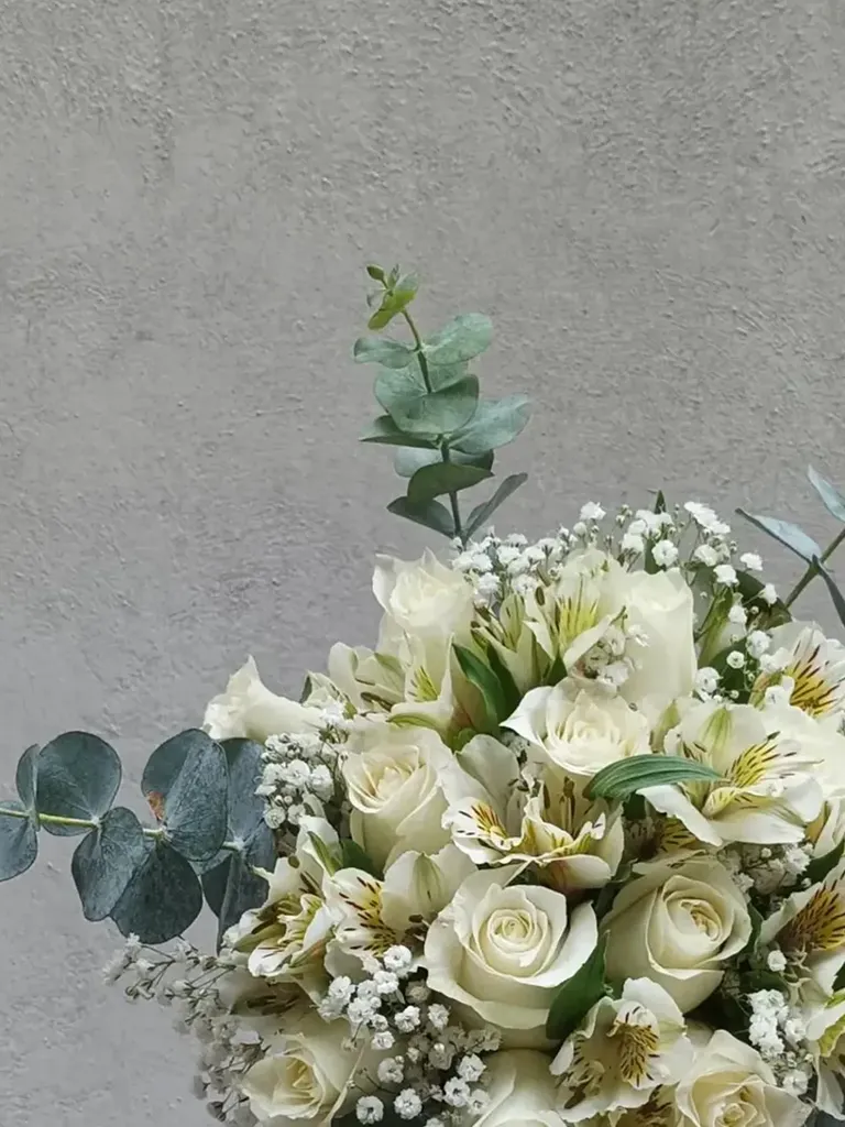 Detalle de bouquet de novia con rosas blancas, astromelias y eucalipto