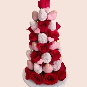Torre de fresas bañadas en chocolate rosado con rosas rojas para eventos