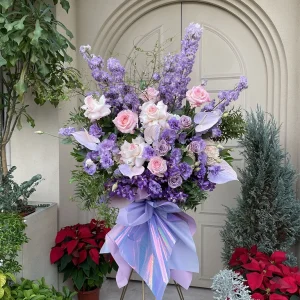 Arreglo floral de pedestal con flores lilas y moradas para inauguración