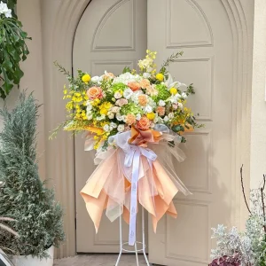 Arreglo floral de pedestal en tonos naranjas y amarillos para inauguración