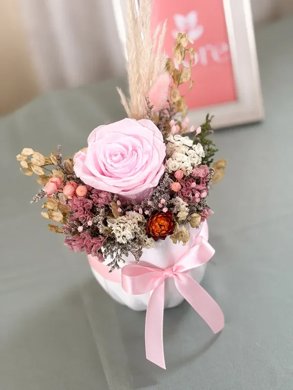 maceta con flores secas y rosa preservada