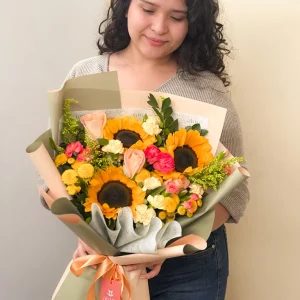 Ramo coreano de girasoles, rosas y flores de colores en papel verde