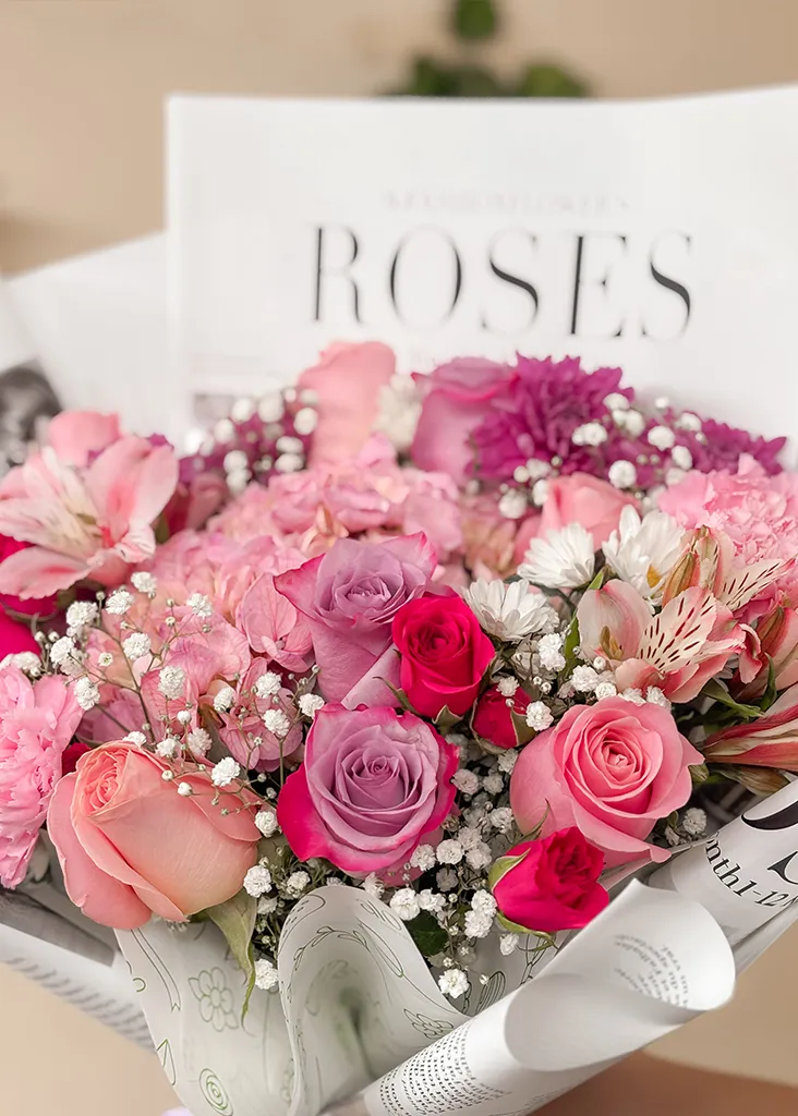 Detalle de rosas lilas y fucsias, claveles y astromelias con gypsophila