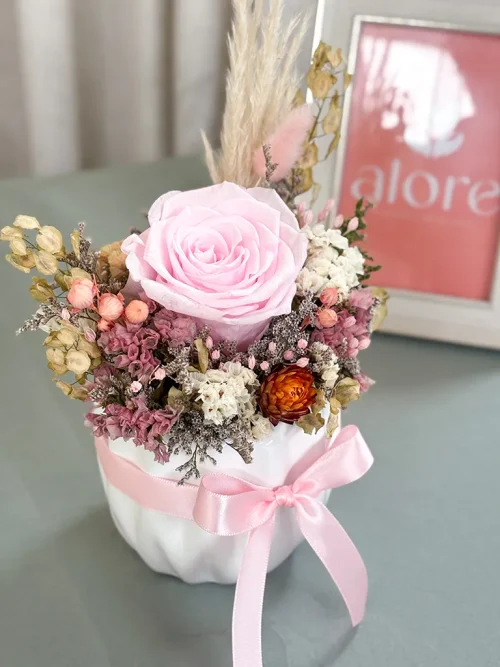 rosa rosada preservada en florero Ramo de flores secas en jarrón con lazo rosa.