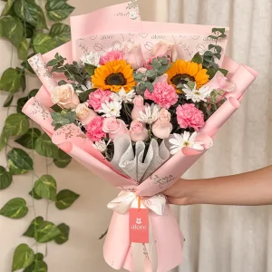Ramo coreano de girasoles, rosas y claveles rosados en papel rosado