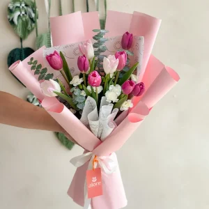 Ramo de tulipanes rosados y blancos con eucalipto en papel rosado