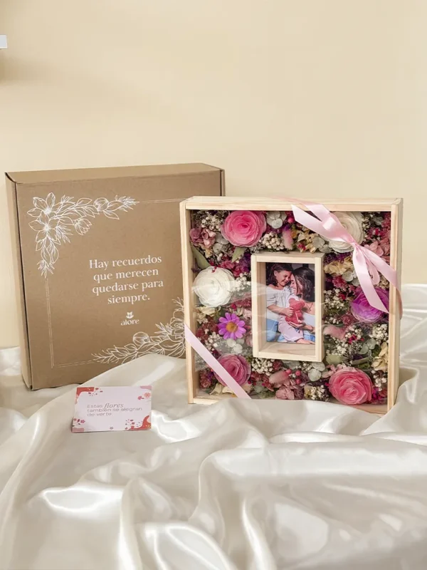 caja con un cuadro de flores secas y fotografia