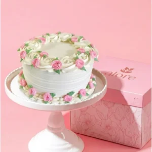 Torta blanca decorada con flores de crema rosadas