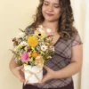 flores eternas amarillas en florero redondo con modelo