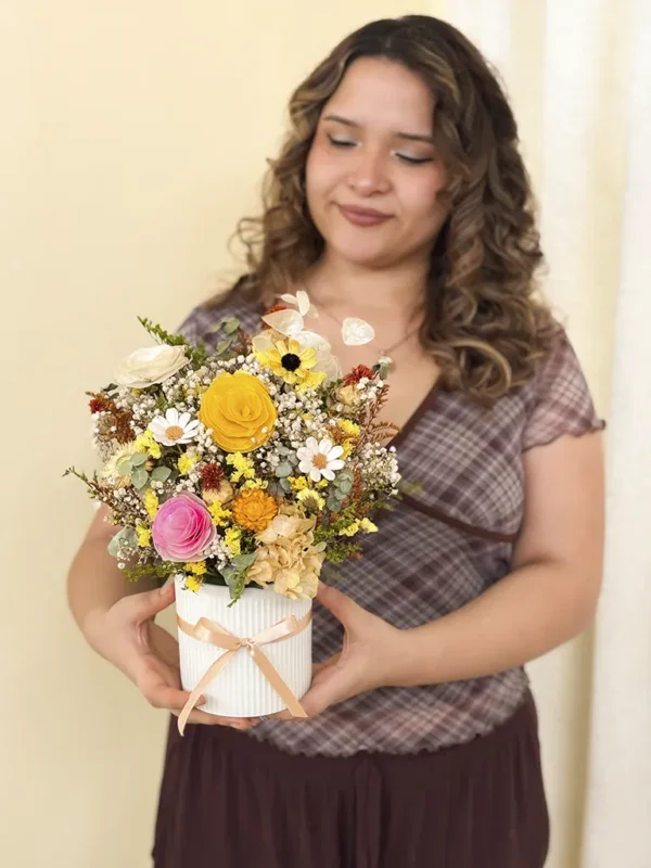flores eternas amarillas en florero redondo con modelo