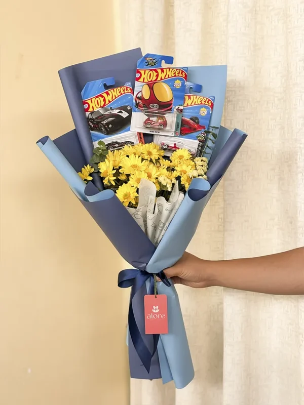 Ramo de flores amarillas con autos Hot Wheels en papel azul